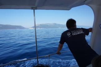 Instructor for scientific diving on a boat with a view into the distance