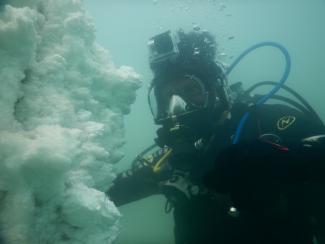 Scientific diver underwater in front of a salt precipitation in the Dead Sea