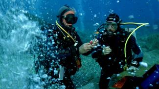 Two scientific divers sampling subhydric volcanic gases