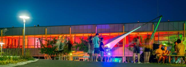 Panoramabild des Campus bei Nacht.