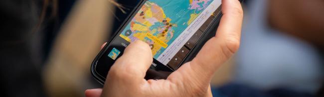 Smartphone mit dem eine Weltkarte fotografiert wird.