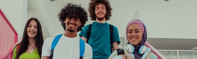 Vier internationales Studierende laufen eine Treppe hinab