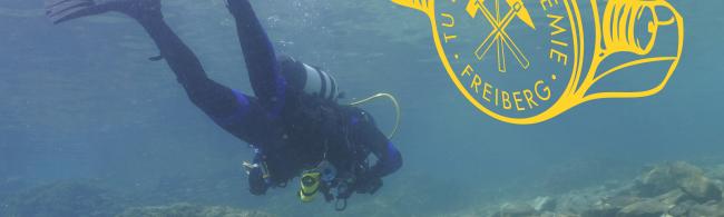 Wissenschaftlicher Taucher vor dem Logo des Scientific Diving Center