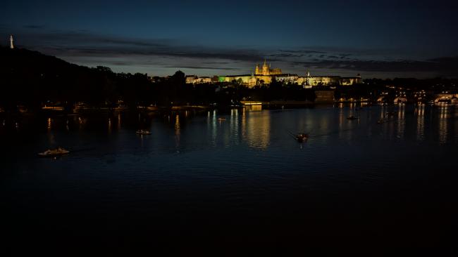 Das beleuchtete Schloss von Prag im Hintergrund fotografiert über die Moldau bei Nacht 