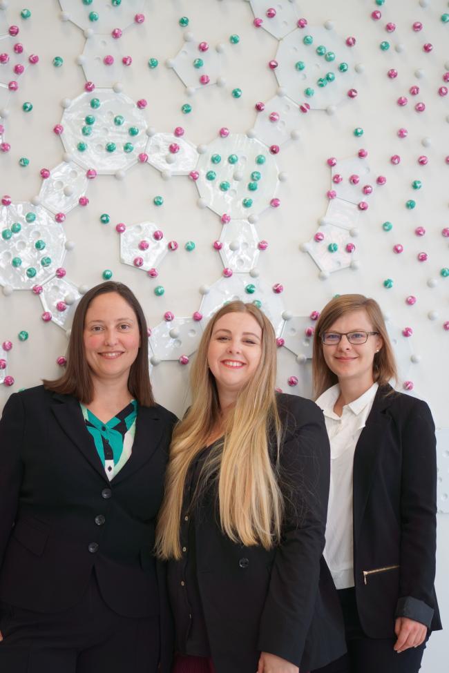 Die 3 Gründerinnen stehen vor einen dekorierten Wand