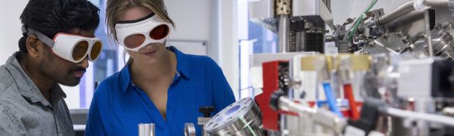 Internationale Studierende an einem Laser-Messgerät.