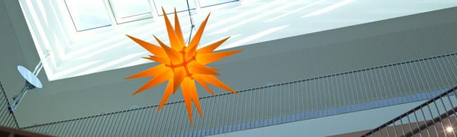 Ein Herrnhuter Stern ist in einem Gebäude aufgehängt. 