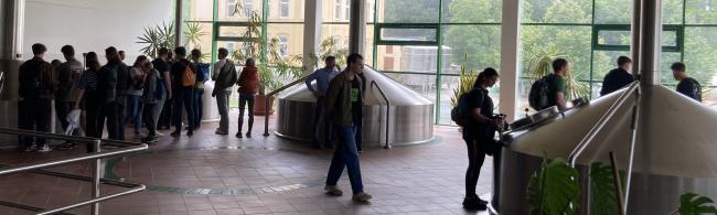 Exkursionsgruppe entdeckt die Brauerei Hartmannsdorf. Die Gruppe schaut sich die Sudkessel an.