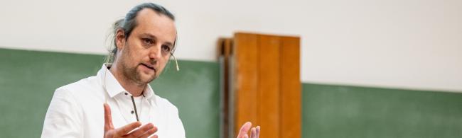 Ein Wissenschaftler hält gestenreich einen Vortrag