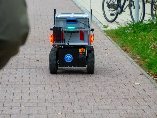 Lieferroboter auf einem Fußweg