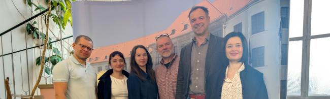 Gäste und Gastgeber stehen für ein Gruppenbild zusammen