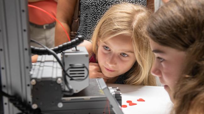 Kinder beobachten einen 3D Drucker