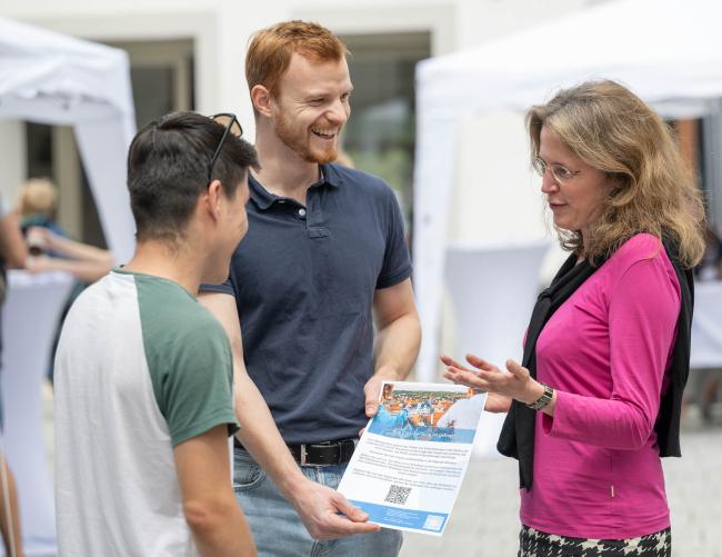 Eine Professorin erklärt zwei Studenten etwas