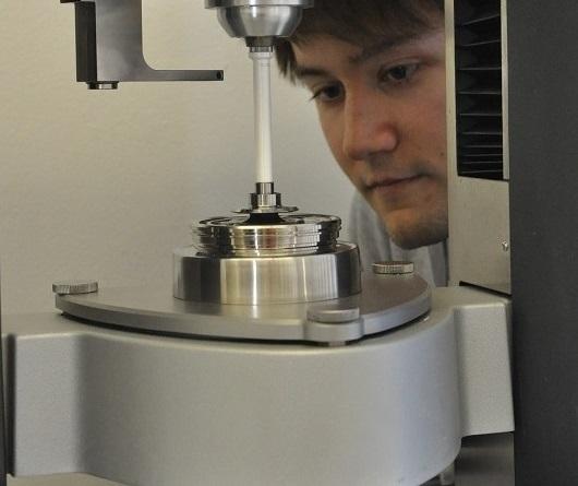 Männliche Person beobachtet eine Messung im Rheometer 