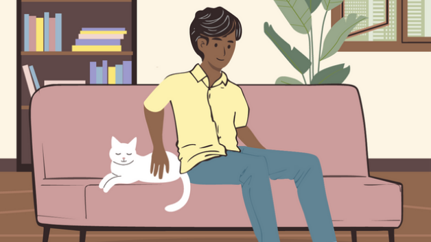 Ein Mann sitzt auf einem Sofa und streichelt eine weiße Katze.