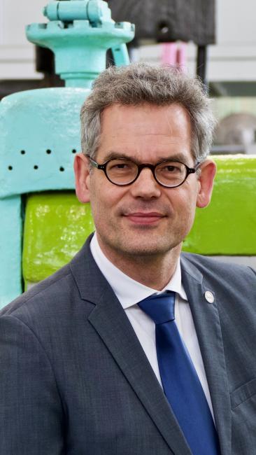 Professor Prahl sitzt vor Walzgerüst 