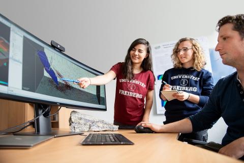 Studierende besprechen Bild auf Monitor