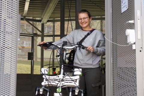 Eine Studentin holt ein Lastenrad aus der Garage