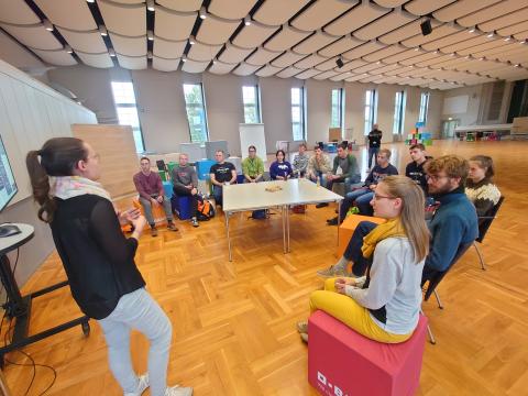 Eine Mitarbeiterin der BASF trägt vor einer Gruppe Studierender vor