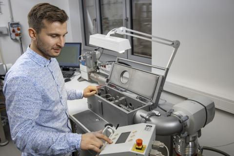 Mann im Hemd steht an einem Dilatometer und bedient Knöpfe