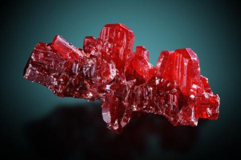 Ein Mineral auf hellroten Kristallen