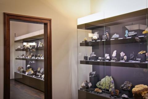 Zwei Vitrinen mit Mineralen in zwei nebeneinander liegenden Räumen.