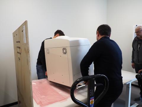 Vorsichtig wird der Spezialscanner auf den Tisch gehoben