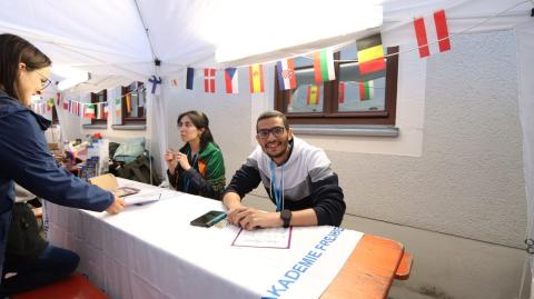 Eine Studentin und ein Student aus dem arabischen Raum am Stand &quot;Schreibe deinen Namen&quot;