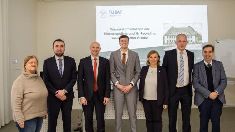 Promovierender mit 6 Mitgliedern der Promotionskommission nach erfolgreicher Verteidigung der Doktorarbeit