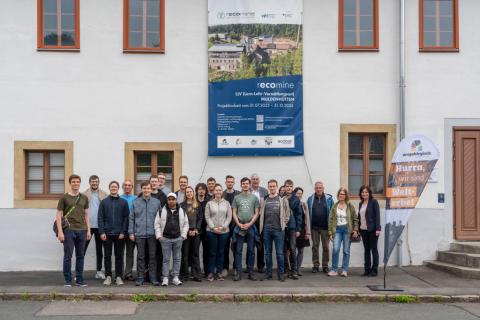 Gruppe steht vor Gebäude.