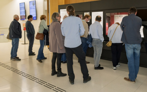 Ein Bild, das Personen vor einer Ausstellungsfläche zeigt.