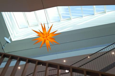 Ein Herrnhuter Stern ist in einem Gebäude aufgehängt.