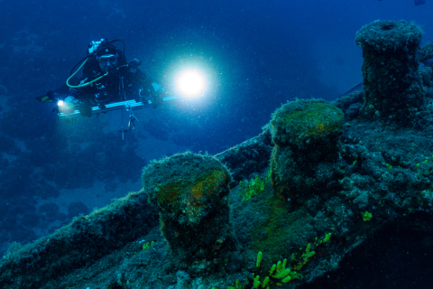 Taucher mit Kameraarm an dem Schiffswrack "Lina"