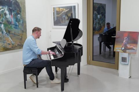 Mann spielt am Klavier.