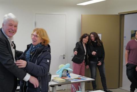 Zwei Personen lösen sich fröhlich aus einer Umarmung.