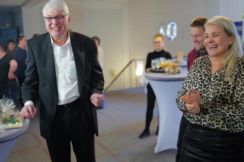 Fröhliche Personen stehen im Foyer.
