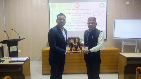 Dr. Gupta holding a gift at IIT Roorkee