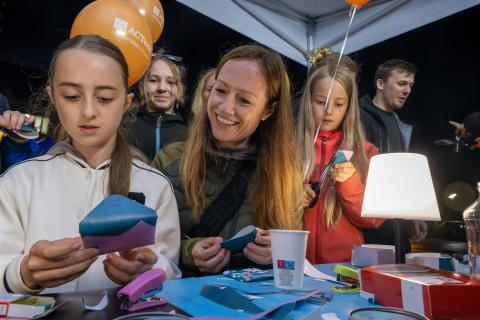 Kinder und Erwachsene basteln an einem Stand