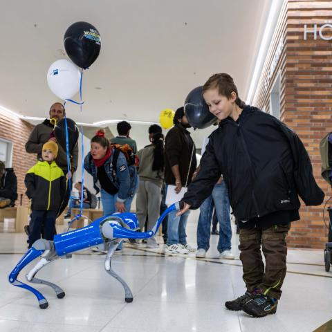 Ein Roboterhund gibt einem Kind Pfötchen