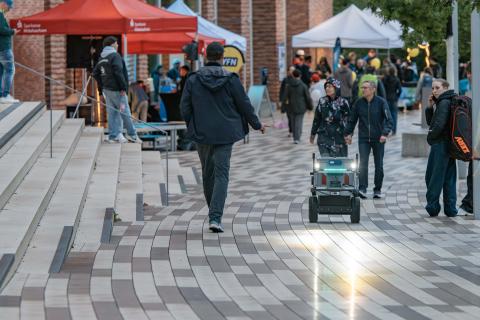 Lieferroboter fährt über ein Volksfestgelände