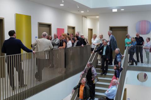 Viele Personen stehen im Treppenhaus und schauen sich Bilder an.
