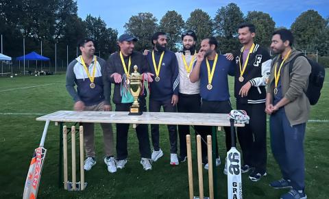 Ein Team männlicher Cricketspieler mit Medaillen