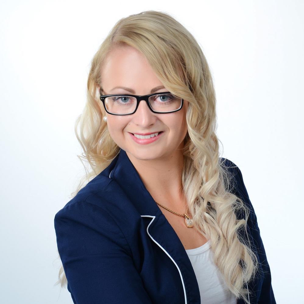 Mitarbeiterfoto von Stefanie Uhlig. Oberkörperportait von einer Frau mit langen blonden Haaren und einer schwarzen Brille. Sie trägt einen dunkelblauen Blazer. 