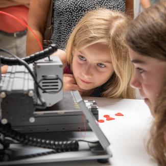 Kinder beobachten einen 3D Drucker