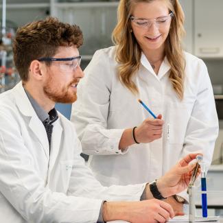 Drei Studierende beim Experimentieren im Labor