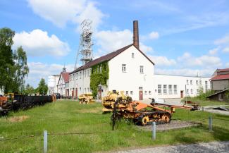 Bergwerksgebäude Reiche Zeche mit historischen Maschinen im Vordergrund