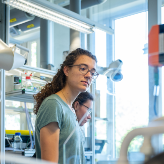 Eine junge Frau schaut sich in einem Labor um.