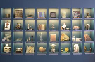 Ansicht der großen Vitrine mit 32 Objekten in 32 Kacheln in der Ausstellung des Historicum