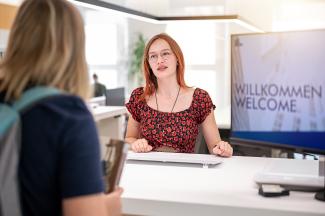 Mitarbeiterin Studierende Bibliothek Theke