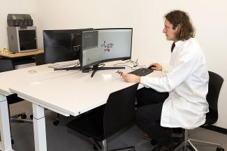 Mitarbeiter im Science Lab mit Bildschirmen und 3D-Drucker